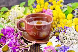 Tea from flowers in clay cup on dark board