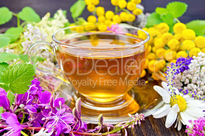 Tea from flowers in glass cup on board