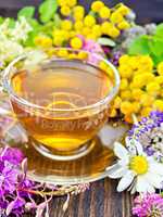 Tea from wild flowers in glass cup on board