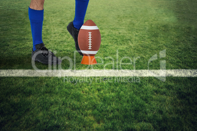 Composite image of american football player kicking ball