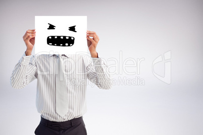 Composite image of businessman holding a white card covering his