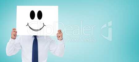 Composite image of tradesman holding blank sign in front of his