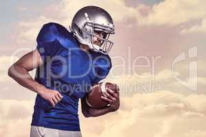 Composite image of american football player holding ball in mid-