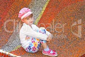 Little girl sitting on the big mosaic panel