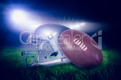 Composite image of american football helmet and ball