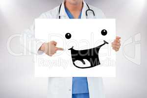Composite image of portrait of a handsome doctor pointing at a b