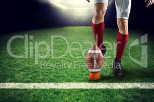 Composite image of low section of sports player kicking ball