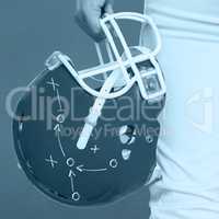 Composite image of american football player holding a helmet