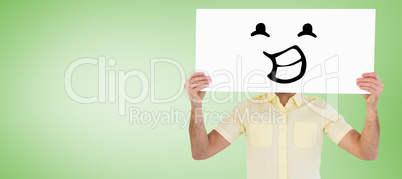 Composite image of man holding card in front of his face