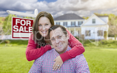 Happy Couple In Front of For Sale Sign and House