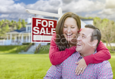 Happy Couple In Front of For Sale Sign and House