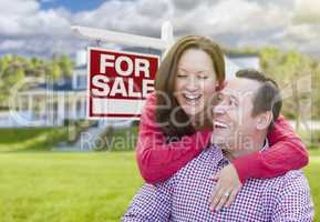 Happy Couple In Front of For Sale Sign and House