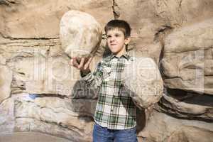 Strong child holds heavy stone