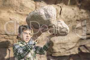 Strong child holds heavy stone