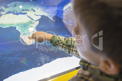 Child pointing Africa on a map