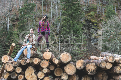 Young woman and men on wood logs