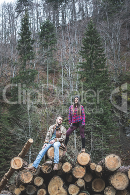 Young woman and men on wood logs