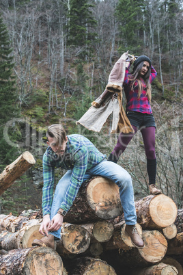 Young woman and men on wood logs