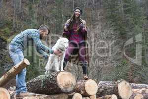 Young woman and men on wood logs