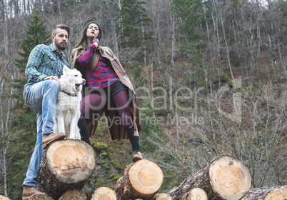 Young woman and men on wood logs