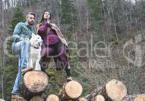 Young woman and men on wood logs