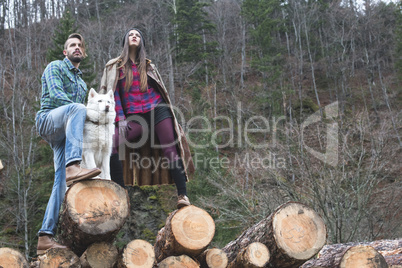 Young woman and men on wood logs