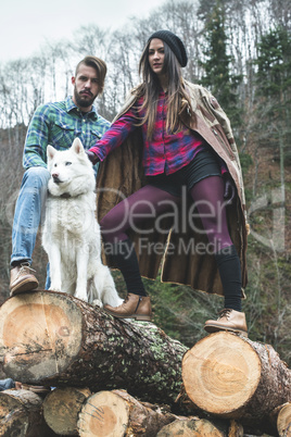 Young woman and men on wood logs