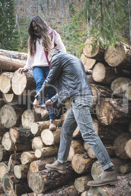 Young woman and men on wood logs