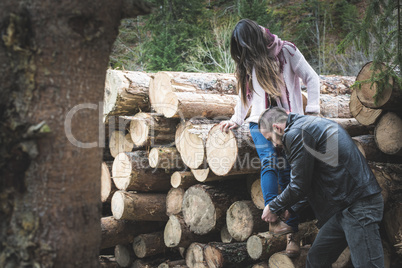 Young woman and men on wood logs