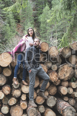 Young woman and men on wood logs