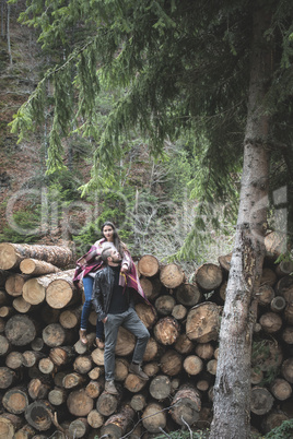 Young woman and men on wood logs