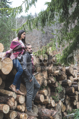 Young woman and men on wood logs