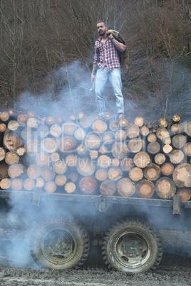 Young man on vintage truck with logs