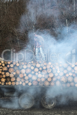 Young man on vintage truck with logs