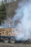 Young man on vintage truck with logs