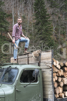 Young man on vintage truck with logs