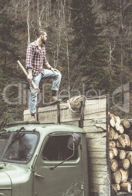 Young man on vintage truck with logs