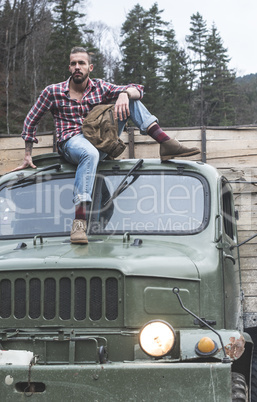 Young man on vintage truck with logs