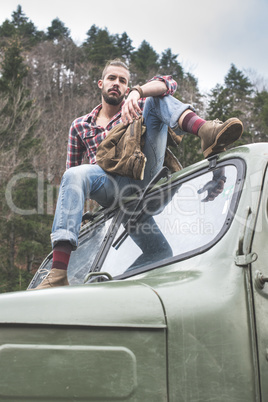 Young man on vintage truck with logs