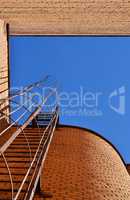 Industrial ladder, blue sky and brick walls of the building