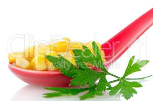 Canned corn in a red ceramic spoon