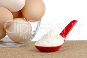 Brown eggs on brown and red ceramic spoon with white powder