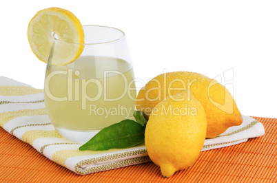 Cup of lemon juice and fresh lemons