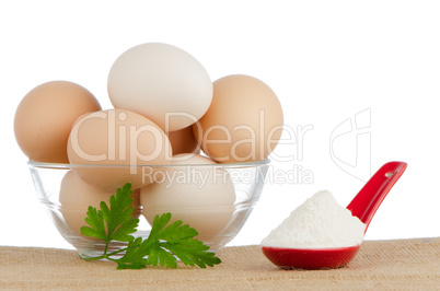 Brown eggs on brown and red ceramic spoon with white powder