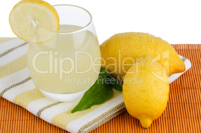 Cup of lemon juice and fresh lemons