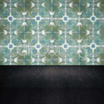 Wood table top and blur vintage ceramic tile pattern wall