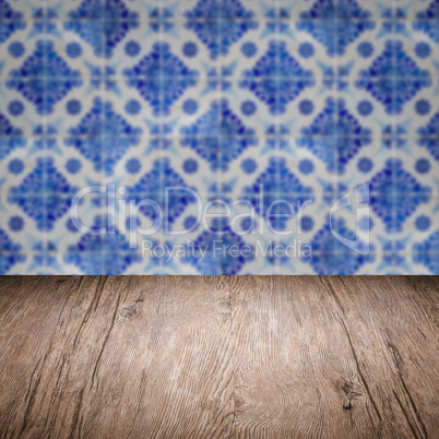 Wood table top and blur vintage ceramic tile pattern wall