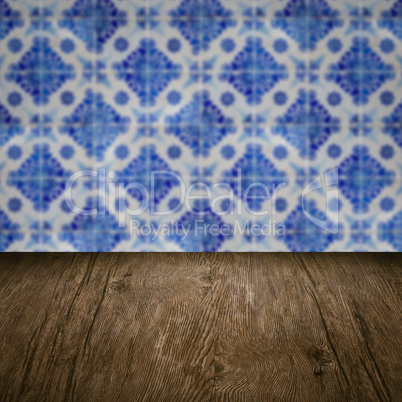 Wood table top and blur vintage ceramic tile pattern wall