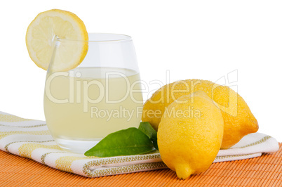 Cup of lemon juice and fresh lemons