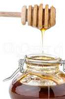Jar of honey with wooden drizzler